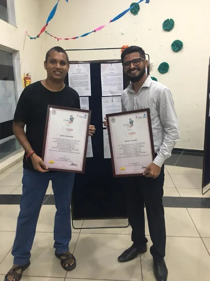 Nikunj and Jatin Chaudhary holding award certificates