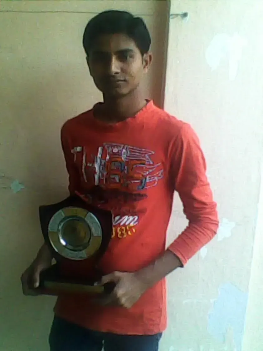 Nikunj holding a trophy at a community felicitation