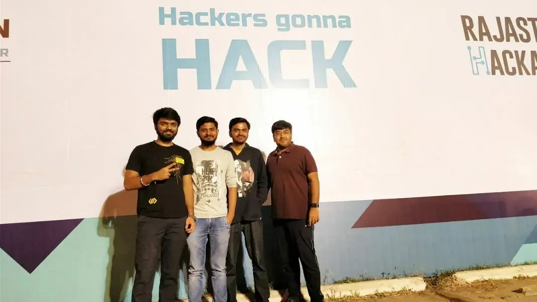 Hackathon team in front of a Hackers gonna hack banner