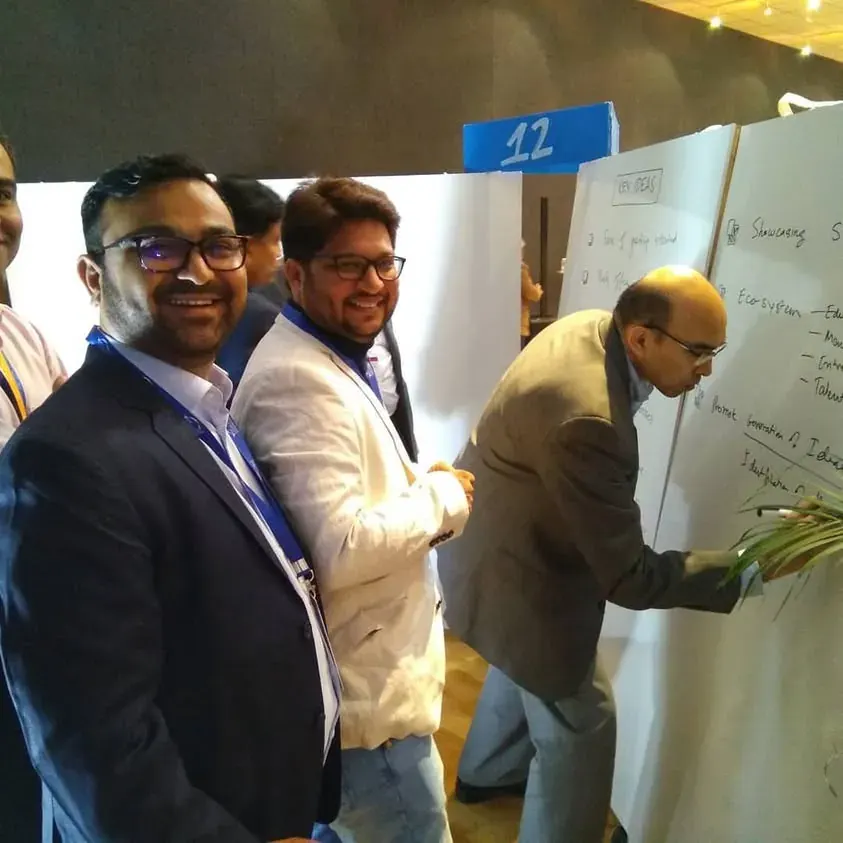 Team members writing on a board at the Vibrant Gujarat action seminar