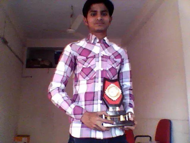 Nikunj holding a trophy after winning a web designing competition