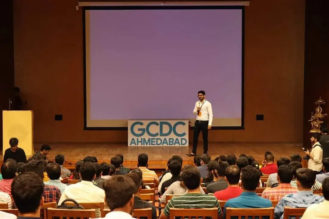 Nikunj on stage in front of a large audience at a GDG Cloud Ahmedabad event
