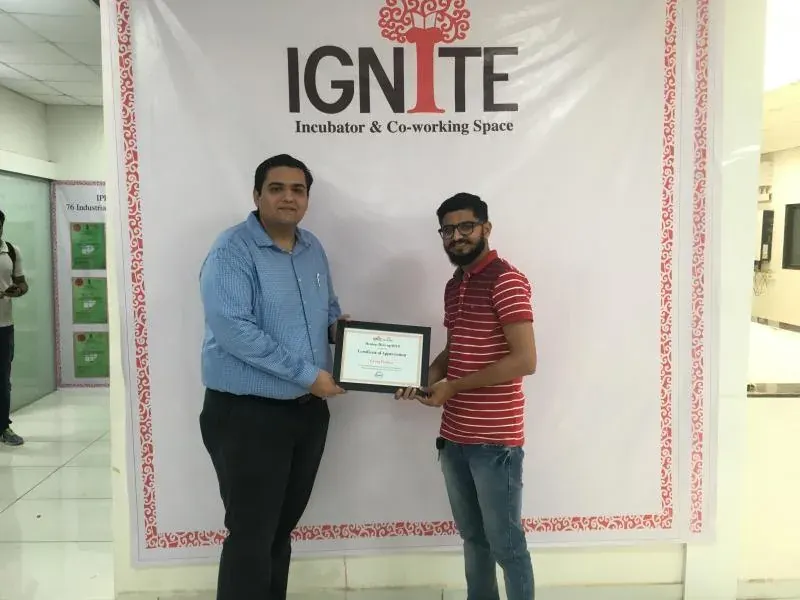 Nikunj receiving a certificate of appreciation in front of an IGNITE Incubator backdrop