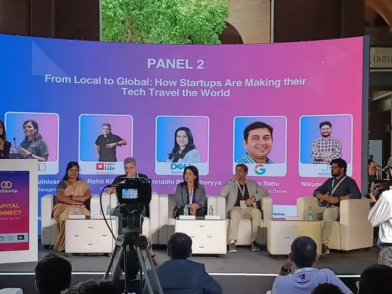 Nikunj moderating a panel on stage
