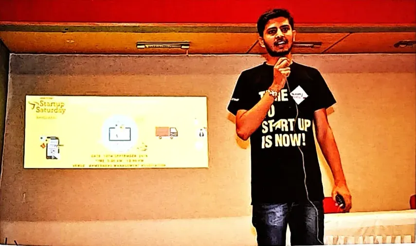 Nikunj hosting Startup Saturday on stage with a mic