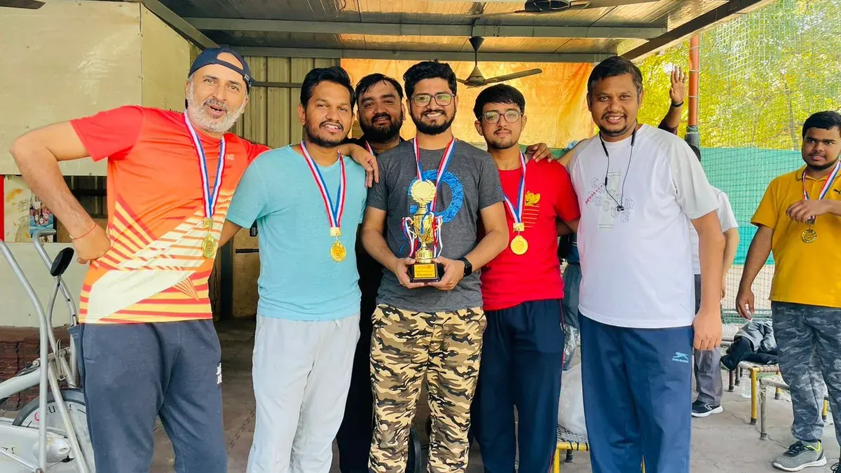 A cricket team holding a trophy